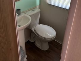 A toilet and sink in a bathroom at Harlyn Hideaway (Swift Barritz) Padstow