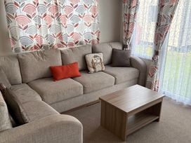 A living room with a sofa and a coffee table at Harlyn Hideaway (Swift Barritz) Padstow