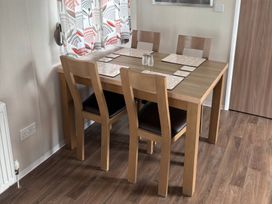 A dining room with a table and chairs at Harlyn Hideaway (Swift Barritz) Padstow