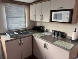 A kitchen with a sink, microwave, kettle and countertop at Harlyn Hideaway (Swift Barritz) Padstow