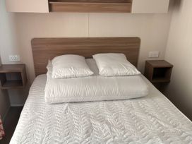 A bed with pillows and bedside tables at Harlyn Hideaway (Swift Barritz) Padstow