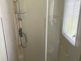 A shower with chrome fittings and a window in Harlyn Hideaway (Swift Barritz) Padstow