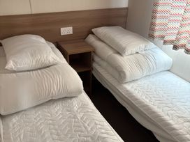 A bedroom with two beds and pillows at Harlyn Hideaway (Swift Barritz) Padstow