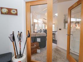 An entrance hall with walking poles and clocks at Waters Edge Lodge in Windermere