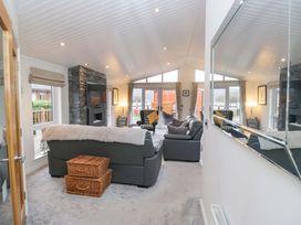 A living room with seating and a fireplace at Waters Edge Lodge in Windermere