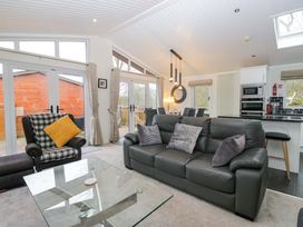 A living room with a black sofa and coffee table at Waters Edge Lodge in Windermere