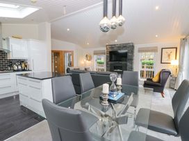A dining area with a glass table and chairs at Waters Edge Lodge in Windermere