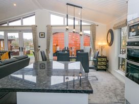 A kitchen with a dining table and chairs at Waters Edge Lodge in Windermere