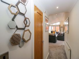 A hallway with wall mirrors and a door at Waters Edge Lodge in Windermere