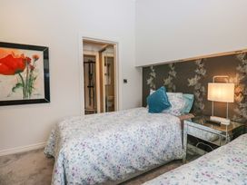 A bedroom with twin beds and a painting at Waters Edge Lodge in Windermere