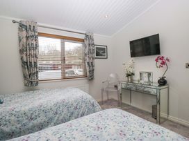 A bedroom with two beds and a TV at Waters Edge Lodge in Windermere