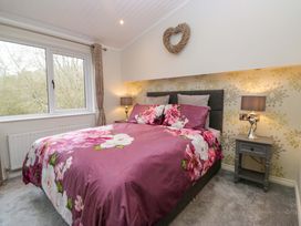A bedroom with a bed and window at Waters Edge Lodge in Windermere