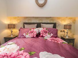 A bedroom with a bed and lamps on nightstands at Waters Edge Lodge in Windermere