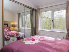 A bedroom with a bed and window at Waters Edge Lodge Windermere