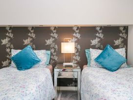 A bedroom with two beds and a lamp at Waters Edge Lodge in Windermere