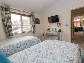 A bedroom with twin beds and a television at Waters Edge Lodge Windermere