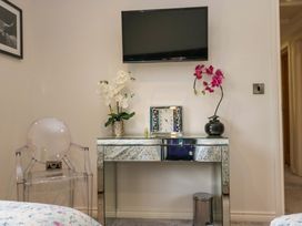 A bedroom with a television and table at Waters Edge Lodge in Windermere