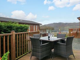 An outdoor seating area with a table and chairs at Waters Edge Lodge in Windermere