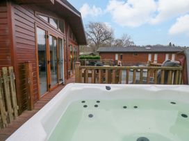 An outdoor space featuring a hot tub and wooden deck at Waters Edge Lodge in Windermere