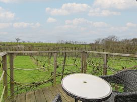 A table and chair overlooking a vineyard at Vine View near Halesworth