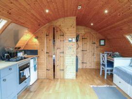 A kitchen with cabinets and dining area at Vine View near Halesworth