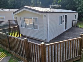 A mobile home with a wooden deck at N5 Ilfracombe