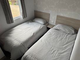 A bedroom with two beds and a window at N5 in Ilfracombe