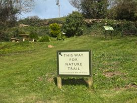 A sign directing to nature trail with a bench in the garden at N5 Ilfracombe