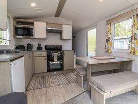 A kitchen with appliances and dining area at N5 Ilfracombe