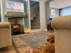 A living room with a fireplace and a dog at York Cottage Southwold