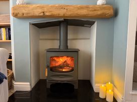 A stove with a fire in a living room at York Cottage Southwold