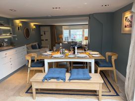 A dining room with a table set for meals at York Cottage in Southwold