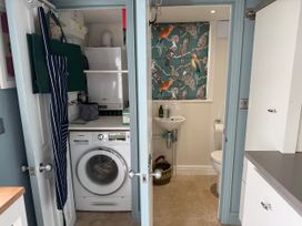 A utility room with a washing machine and sink at York Cottage in Southwold