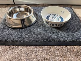A dog bowl and a pet bowl on a mat at York Cottage in Southwold