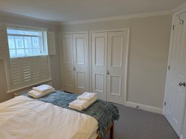 A bedroom with a bed and closet doors at York Cottage Southwold
