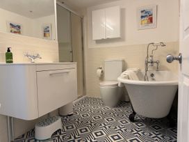 A bathroom with a shower, bathtub, and sink at York Cottage in Southwold