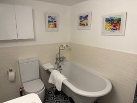 A bathroom with bathtub and toilet at York Cottage Southwold