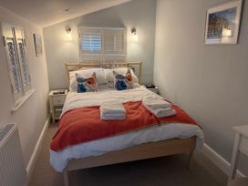 A bedroom with a bed and bedside table at York Cottage in Southwold