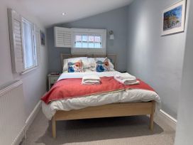A bedroom with a bed and nightstand at York Cottage in Southwold