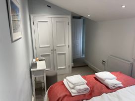 A bedroom with a bed and towels at York Cottage Southwold