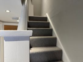 A staircase with a carpet and handrail at York Cottage Southwold