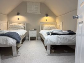 A bedroom with two beds and a nightstand at York Cottage Southwold