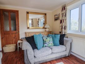 A living room with a sofa and cushions at Regenna in Seaton