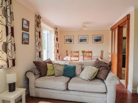A living room with a sofa and dining table at Regenna in Seaton