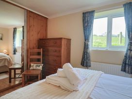 A bedroom with a wooden dresser and a chair at Regenna in Seaton