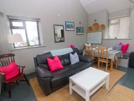 A living room with a sofa and dining table at Brewery Cottage
