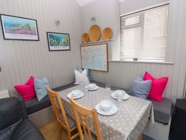 A dining area with a table set for meals at Brewery Cottage