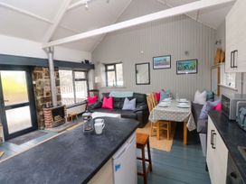 A living room with a couch and dining table at Brewery Cottage