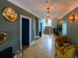A hallway with a staircase and chairs at Picton House near St Clears