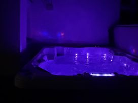 A hot tub with LED lights in an indoor bathroom at Picton House near St Clears
